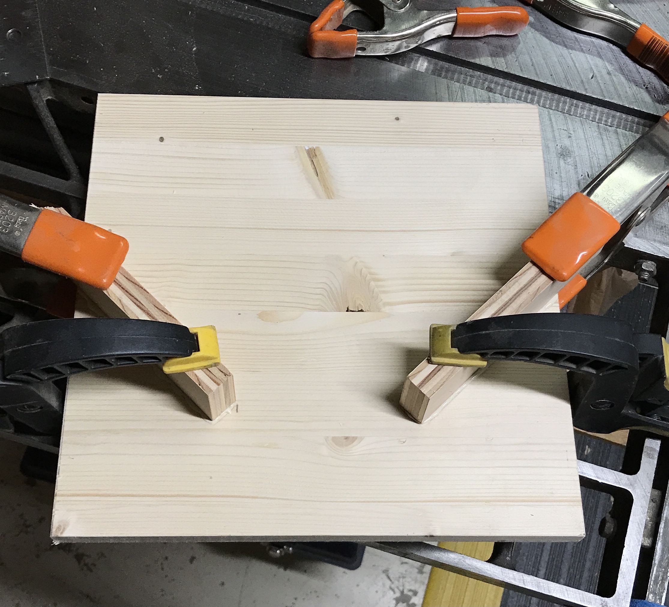 The two boards glued to the frame of the corner splining jig